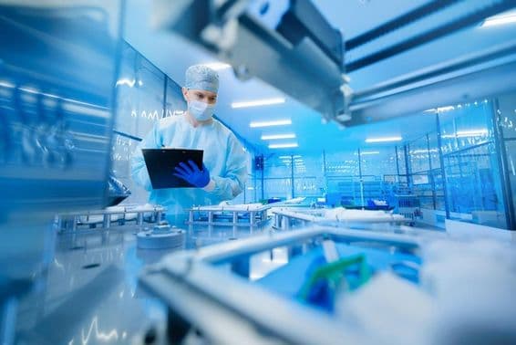Trabalhador farmacêutico operando uma linha de produção na indústria farmacêutica.