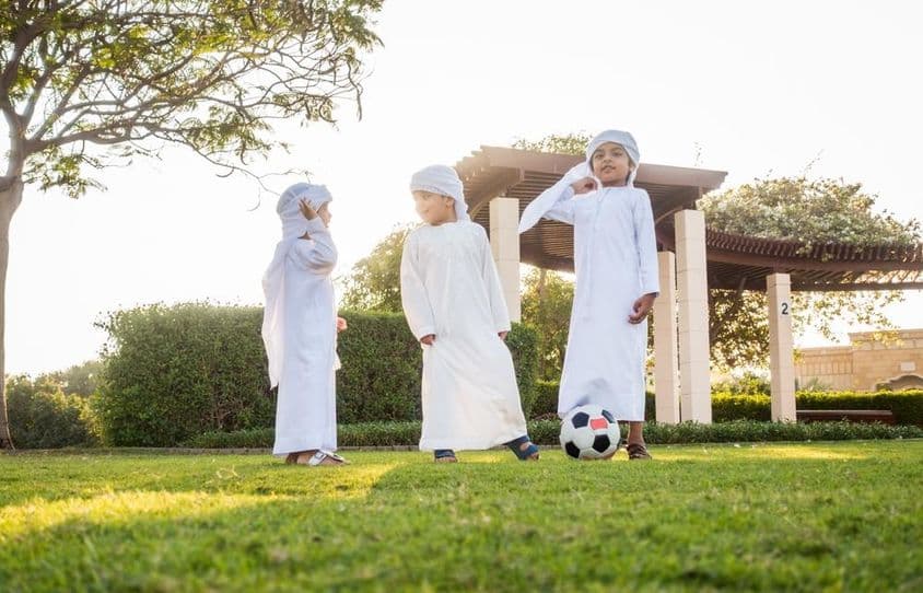 Um grupo de crianças do Oriente Médio brincando e se divertindo ao ar livre.