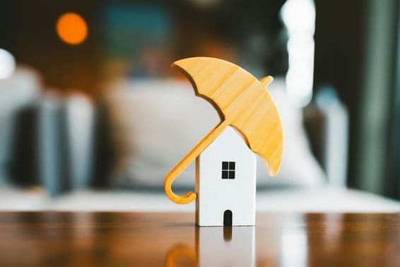 Modelo de guarda-chuva em cima de casa de madeira, seguro residencial.