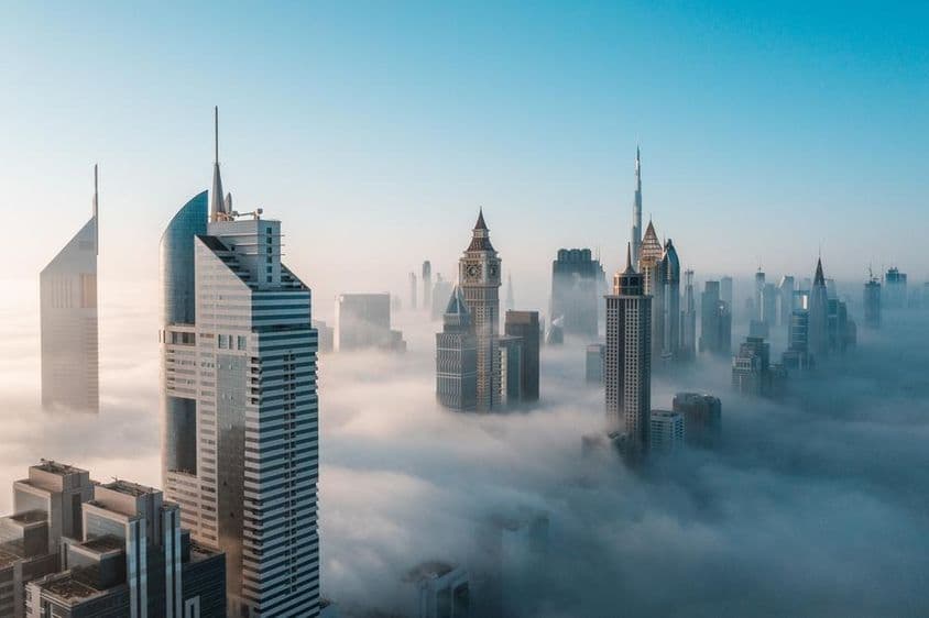 Arranha-céus mega-altos de Dubai encobertos pela neblina ao amanhecer.