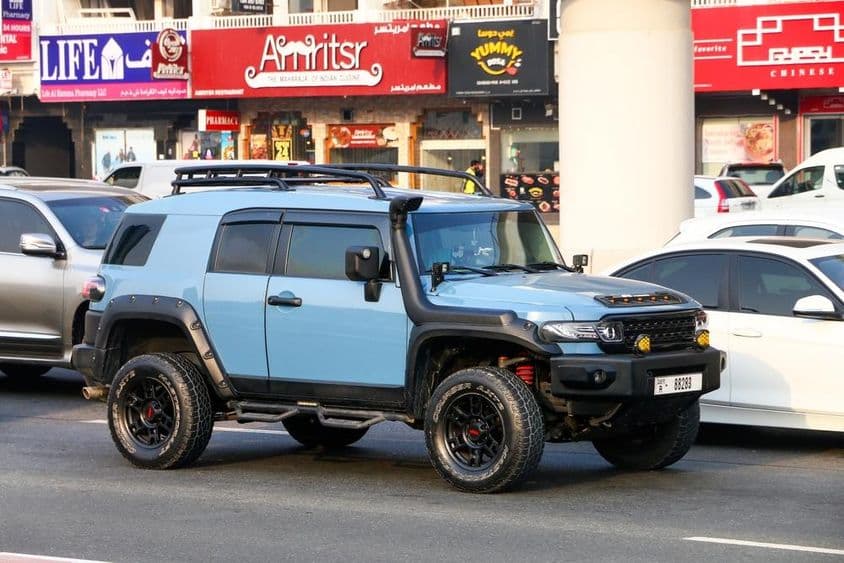 Carro off-road Toyota FJ Cruiser em rua da cidade.