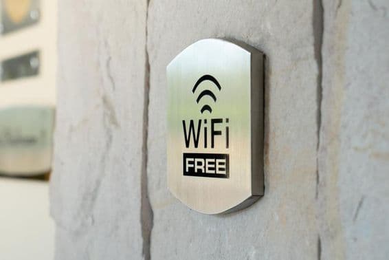 Placa metálica de WIFI em uma parede de hotel.