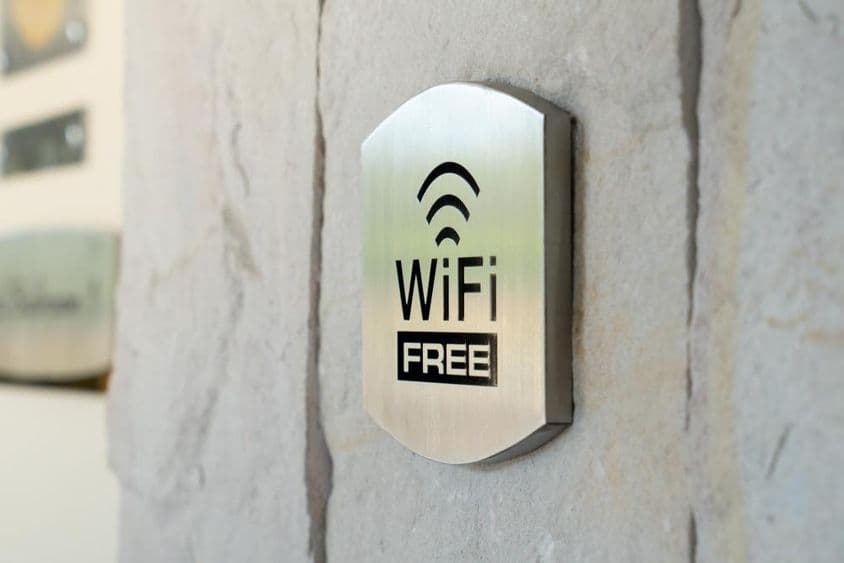 Placa metálica de WIFI em uma parede de hotel.