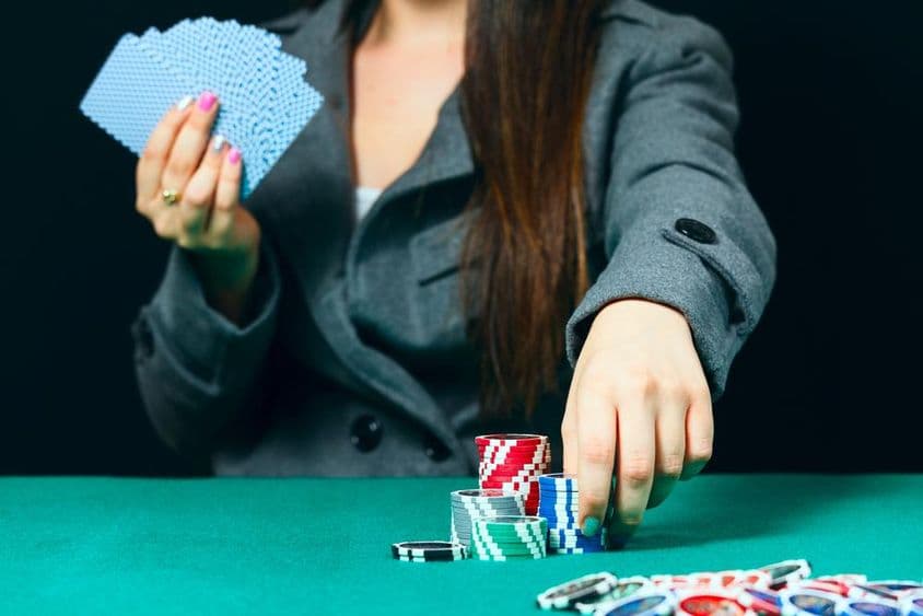Blackjack em um cassino, uma mulher faz uma aposta com fichas.