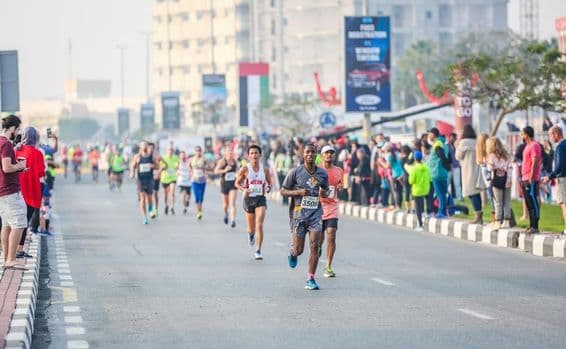Corredores de maratona e vencedores durante uma meia maratona em curso de rua.