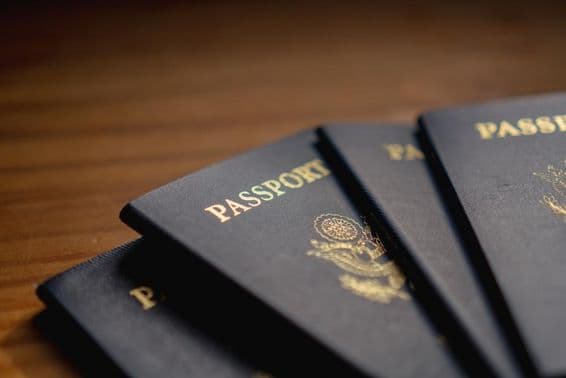 Passaportes empilhados sobre uma mesa de madeira.