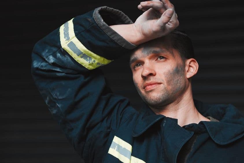 Bombeiro exausto durante extinção de incêndio.