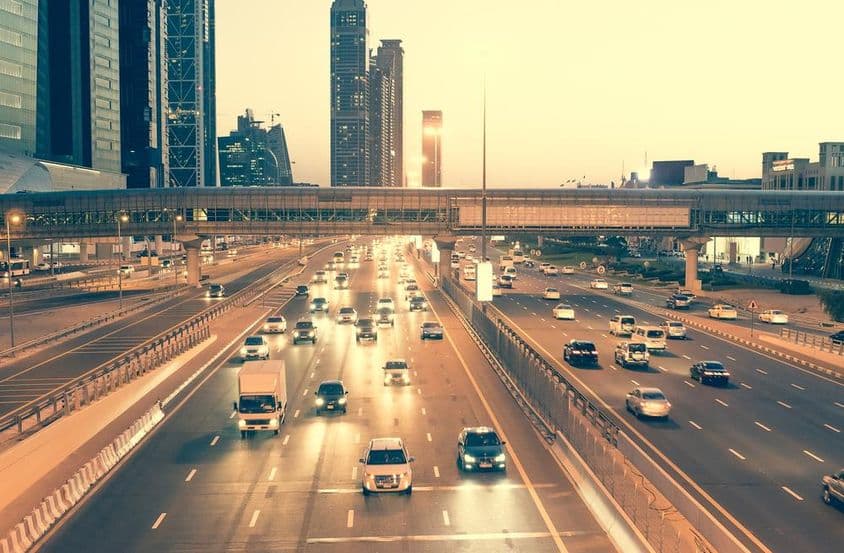 Arranha-céus, estradas e ponte na Sheikh Zayed Road em Dubai à noite.