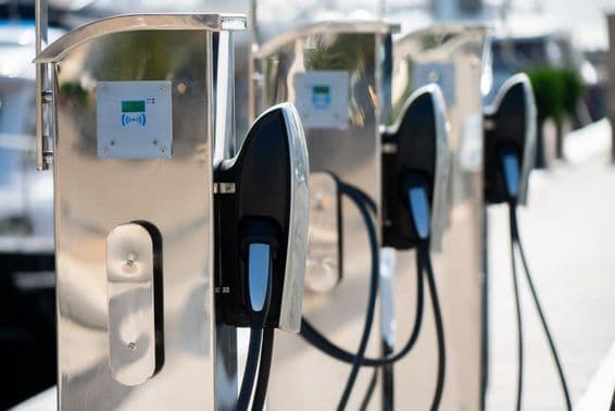 Estação de carregamento de carro elétrico em uma marina de luxo à beira-mar.