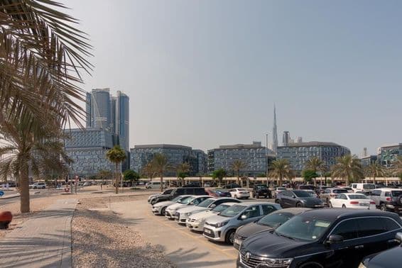 Carros estacionados em Dubai com Burj Khalifa ao fundo.