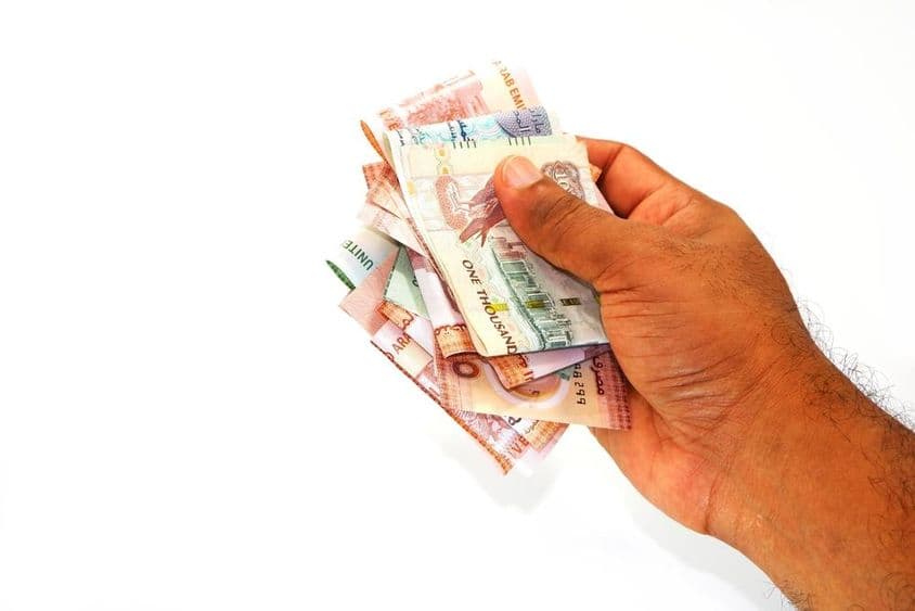 Notas de dirham na mão de um homem.
