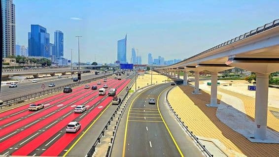 Em Dubai, a estrada é pintada de vermelho com marcações brancas de faixa e placas de limite de velocidade indicando 100 km/h.