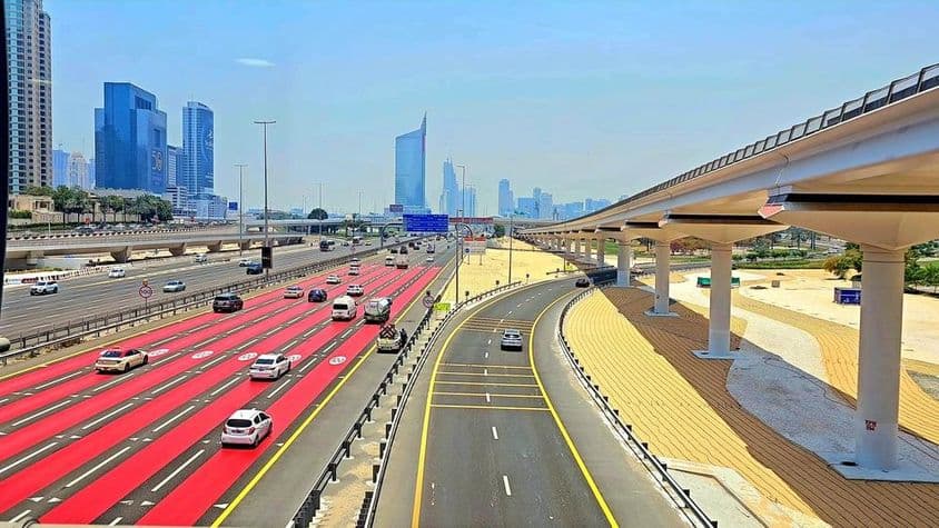 Em Dubai, a estrada é pintada de vermelho com marcações brancas de faixa e placas de limite de velocidade indicando 100 km/h.