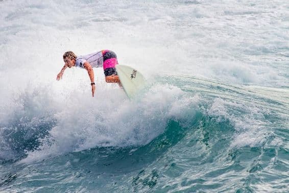 Jovem surfista deslizando em uma grande onda.