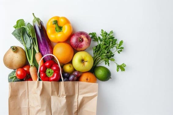 Comida saudável em um saco de papel, vegetais e frutas.