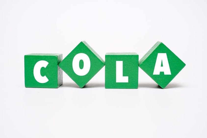 Um bloco de madeira colorido com a palavra COLA escrita.