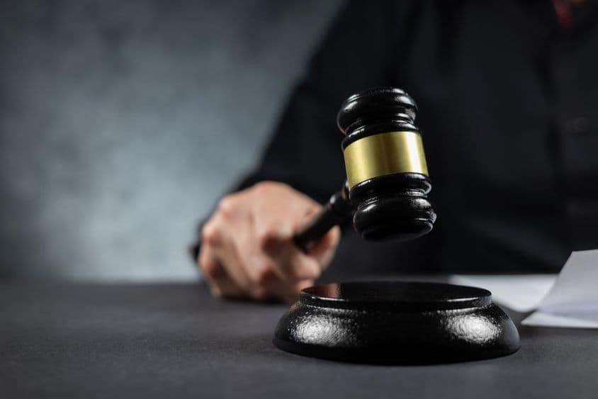 Um juiz segurando um martelo no tribunal.