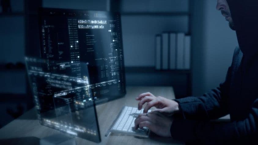 Hacker cibernético usando algoritmos avançados para invadir sistemas de cibersegurança.