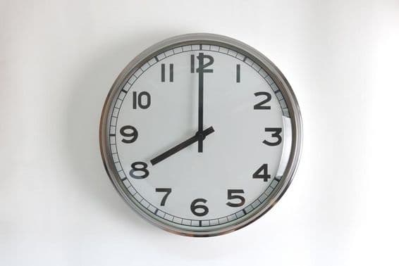 Relógio de parede redondo de aço inoxidável com mostrador branco.
