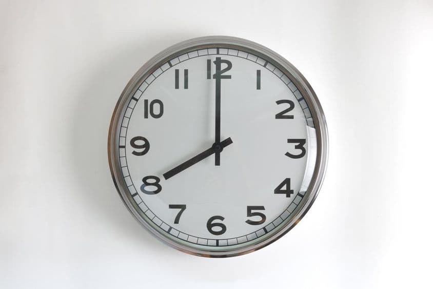 Relógio de parede redondo de aço inoxidável com mostrador branco.
