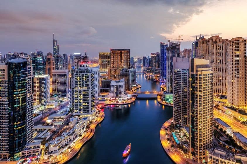 Dubai Marina com arranha-céus iluminados.