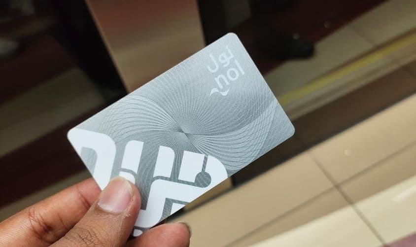 Viajante em Dubai segurando um passe de entrada do metrô cartão Nol.