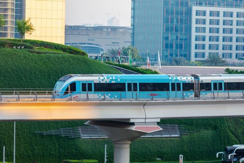Trem de metrô sem condutor movendo-se na cidade de Dubai em um dia ensolarado.