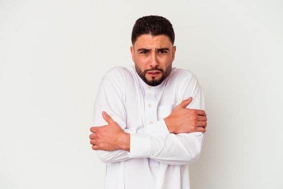 Jovem árabe com trajes tradicionais tremendo de frio.