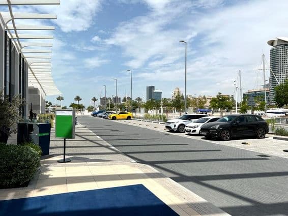 Estacionamento em Dubai com horizonte da cidade ao fundo em um dia de verão.