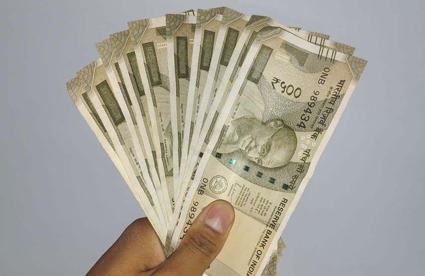 Segurando notas de 500 rúpias indianas.