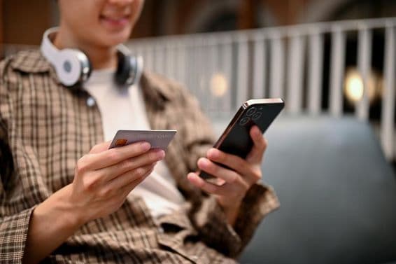 Um homem asiático usando serviço de pagamento com cartão de crédito em um aplicativo de compras online.
