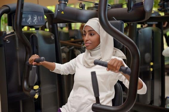 Jovem mulher se exercitando em uma academia.