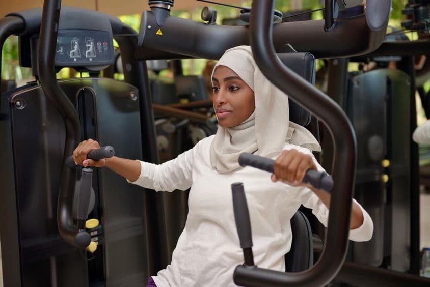 Jovem mulher se exercitando em uma academia.