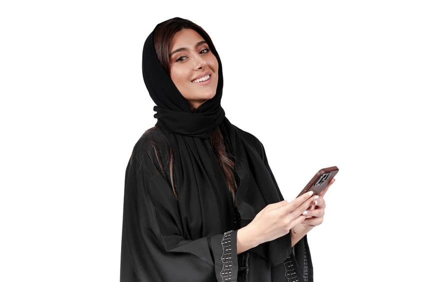 Empresária emirati de abaya árabe trabalhando no celular.