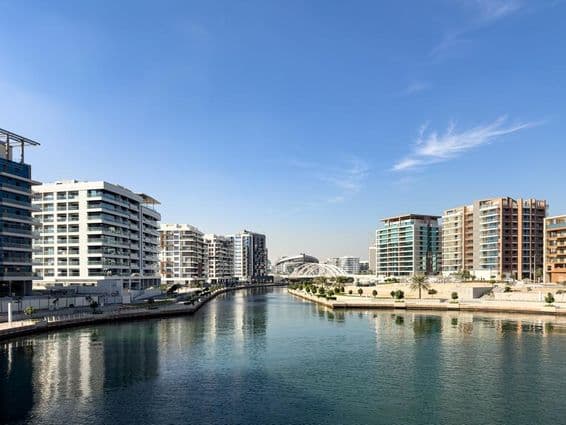 Edifícios residenciais e canal no bairro de Al Raha Beach em Abu Dhabi.
