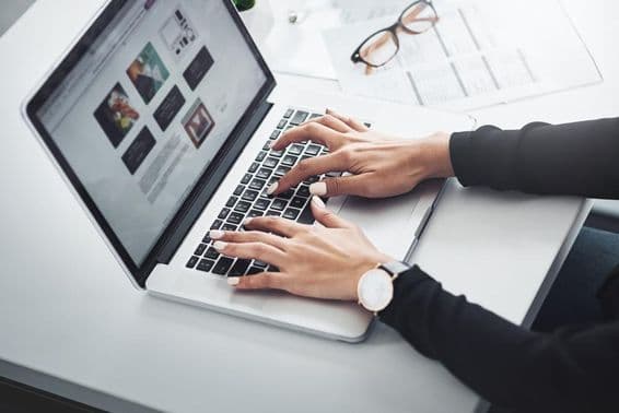 Mulher trabalhando remotamente de casa usando um laptop.