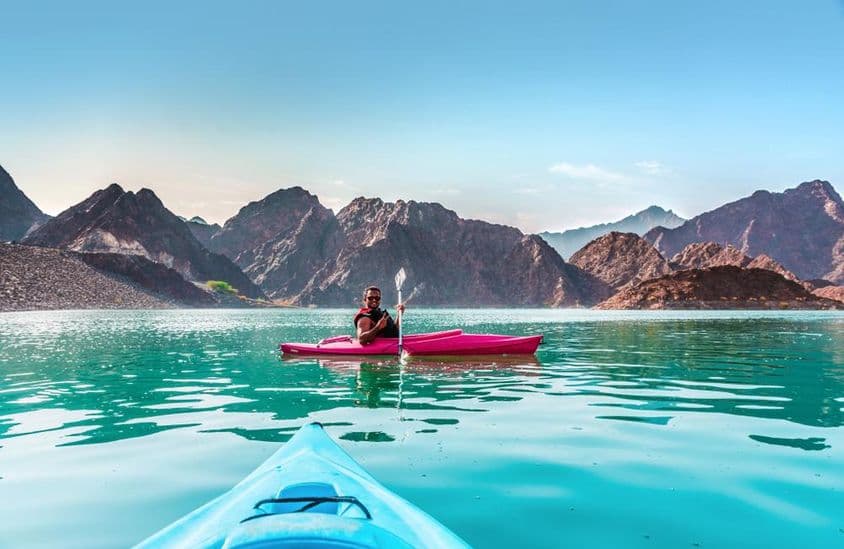 Jovem praticando caiaque na Represa Hatta, o melhor lugar para atividades de aventura aquática, em Dubai.