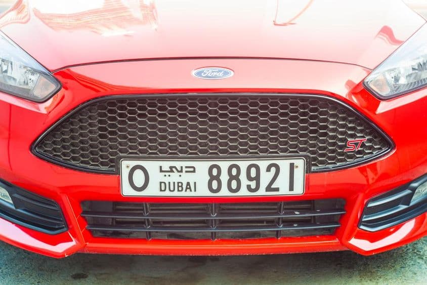Frente de um carro esportivo moderno com placa de Dubai.
