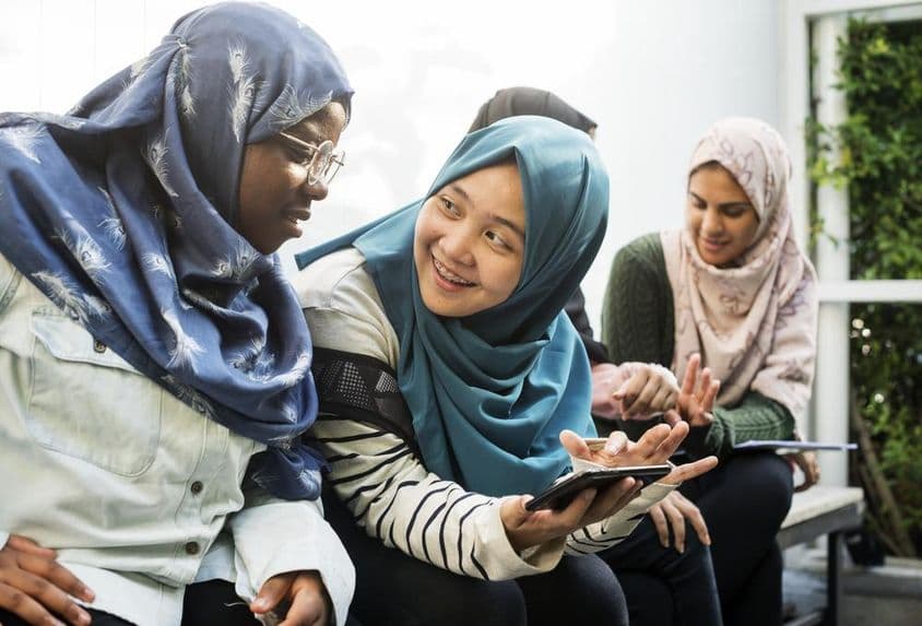 Grupo de estudantes usando telefones móveis.