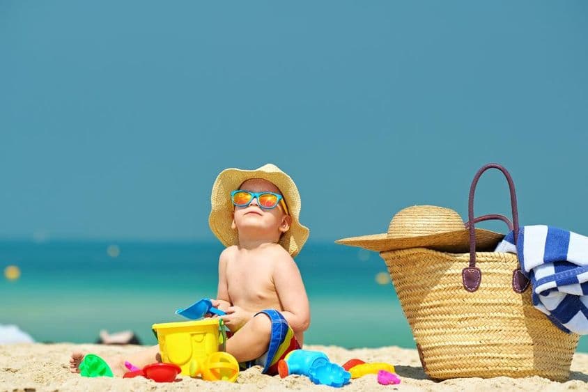 Menino de dois anos brincando na praia.