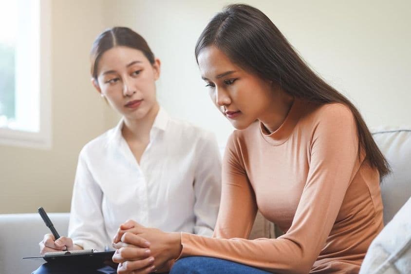 Jovem asiática triste consultando um psicólogo.