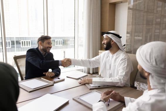 Parceiros de negócios multinacionais concluindo uma negociação bem-sucedida com um aperto de mão.