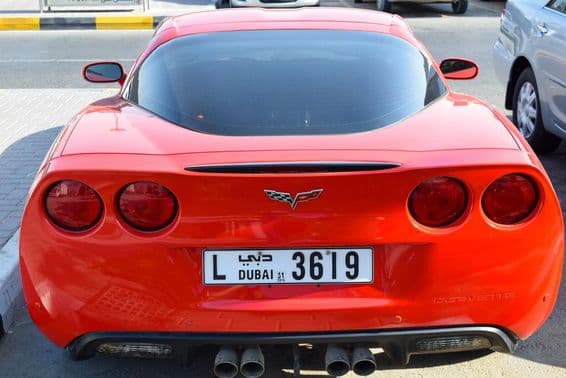 Chevrolet Corvette vermelho com placa de Dubai.