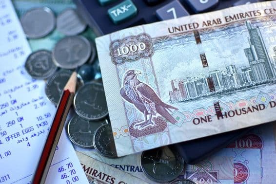 Nota de 1000 dirhams dos EAU e um punhado de moedas.