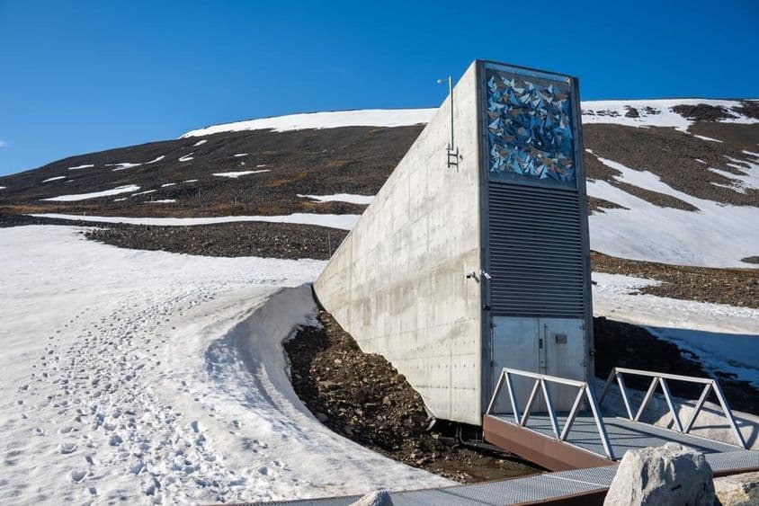Edifício de entrada do Svalbard Global Seed Vault cercado por neve em Svalbard, Noruega.
