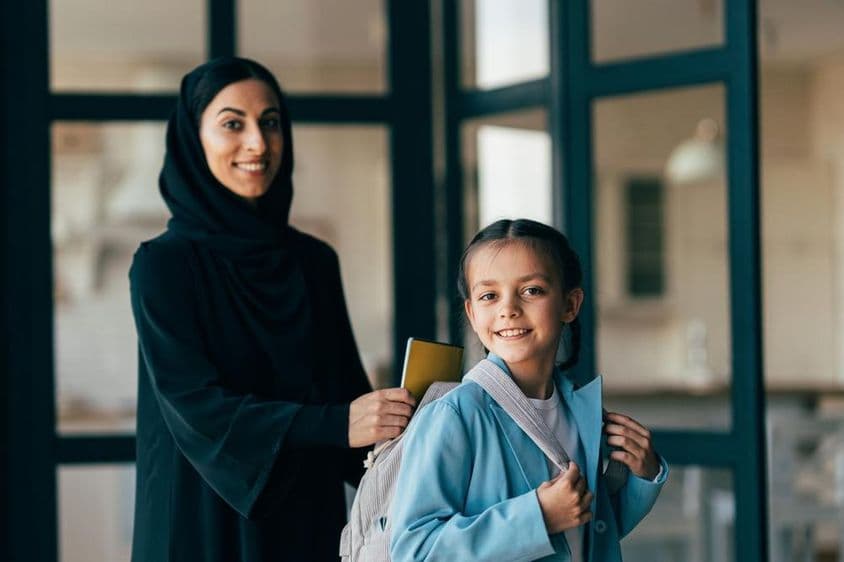 Família árabe tradicional de Dubai, jovem garota indo para a escola.