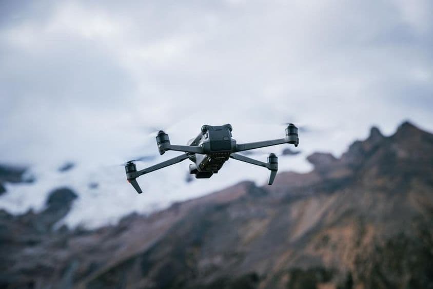 Drone voando sobre o topo de uma montanha de alta altitude.