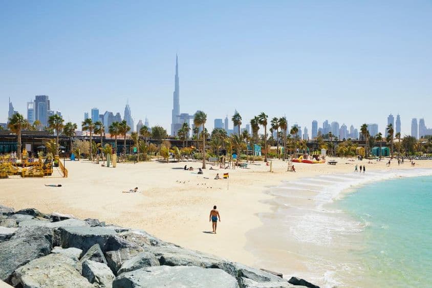 Praia com horizonte de Dubai ao fundo, Emirados Árabes Unidos.