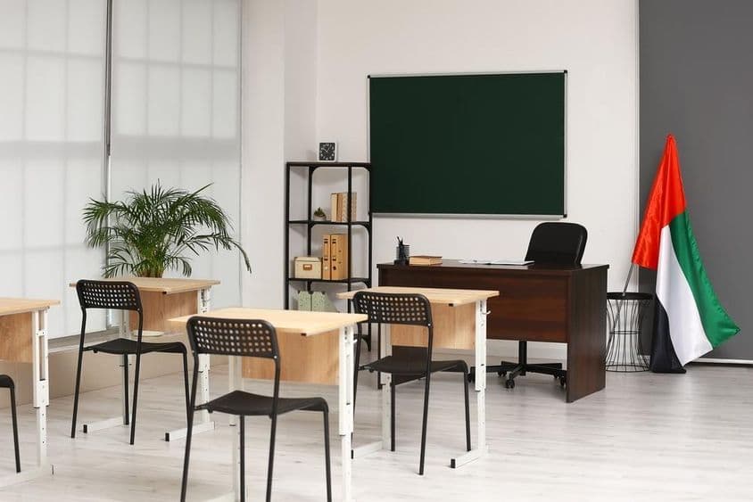 Interior de uma sala de aula com a bandeira dos Emirados Árabes Unidos.