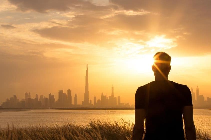Silhueta de um homem observando o belo horizonte da cidade ao pôr do sol.